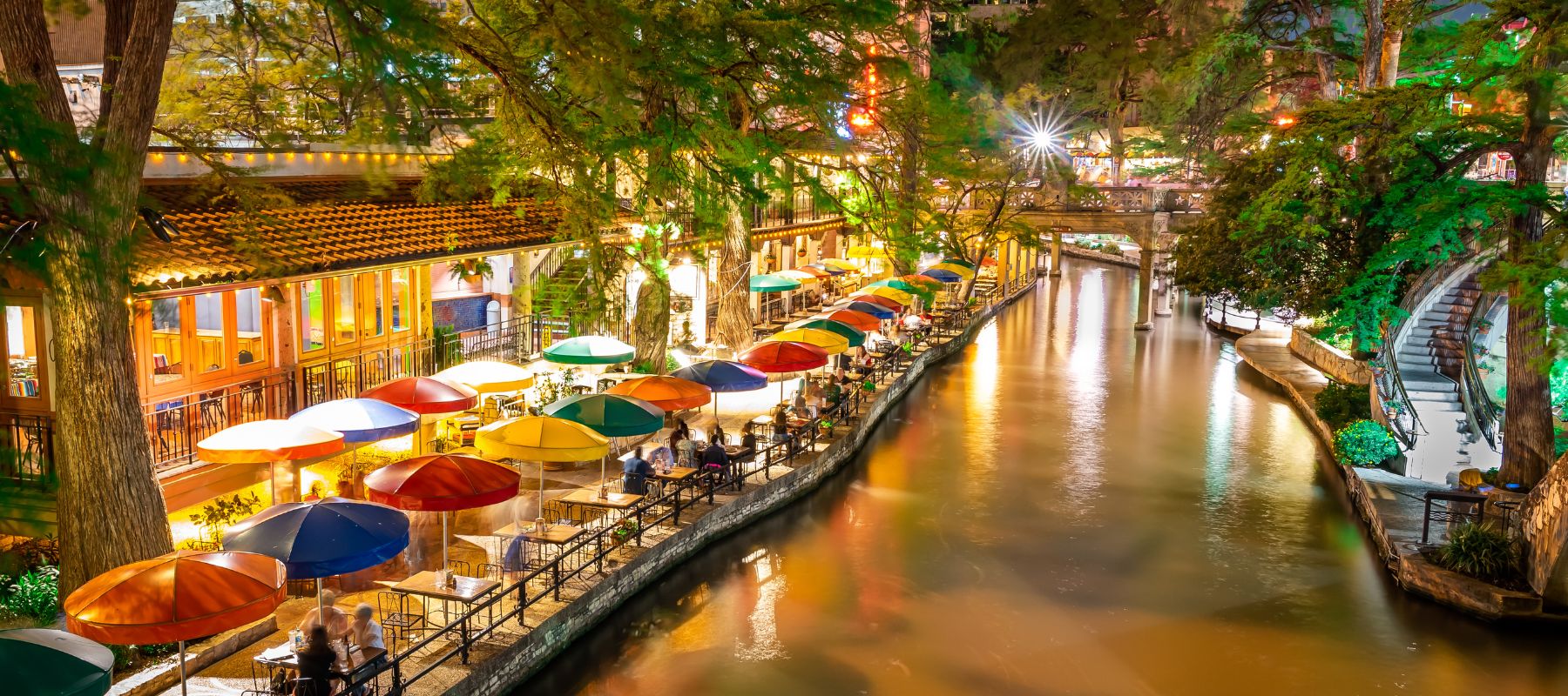 downtown san antonio riverwalk at night showing a riverwalk restaurant