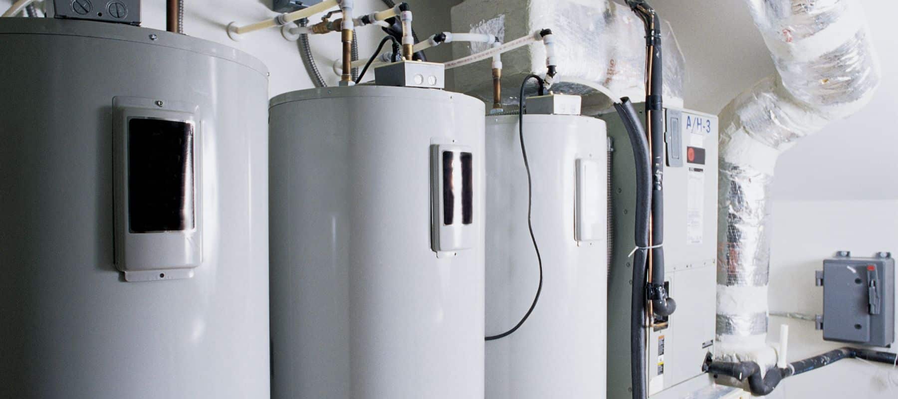 tanked water heaters lined up on a wall in a commercial san antonio building