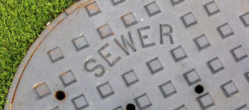 closeup of a manhole cover labeled sewer