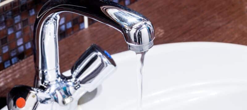 closeup of a water faucet with water dripping out of it