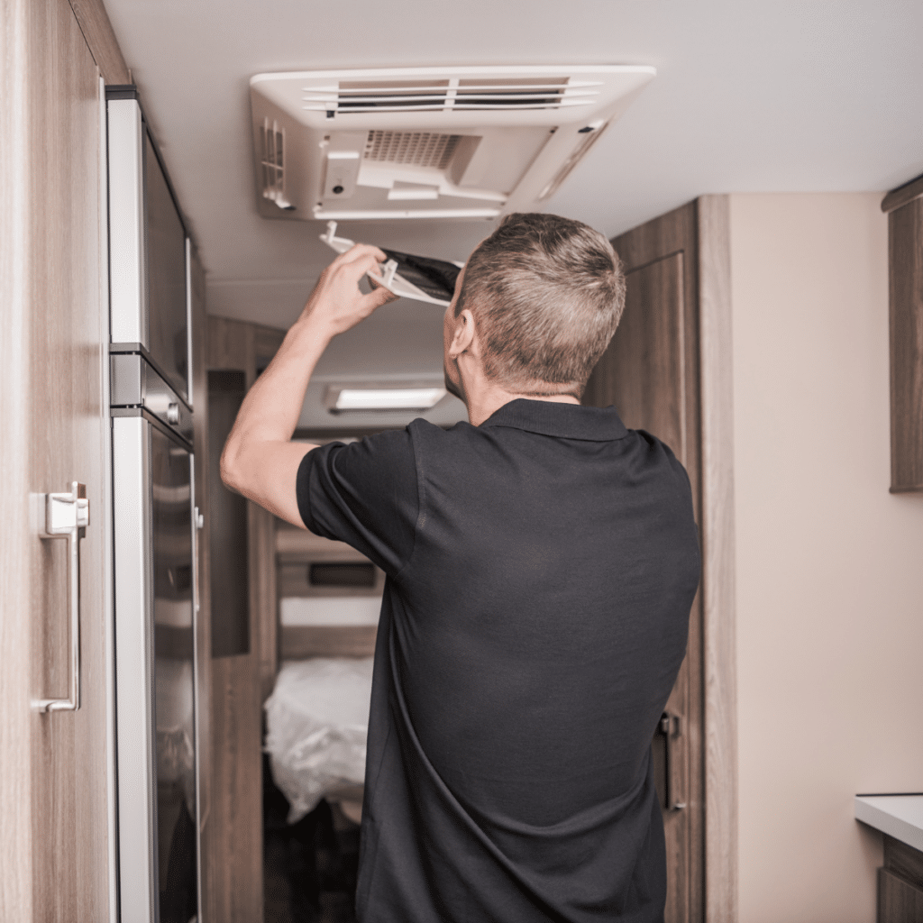 technician adjusting or inspecting a ceiling air vent in a residential space