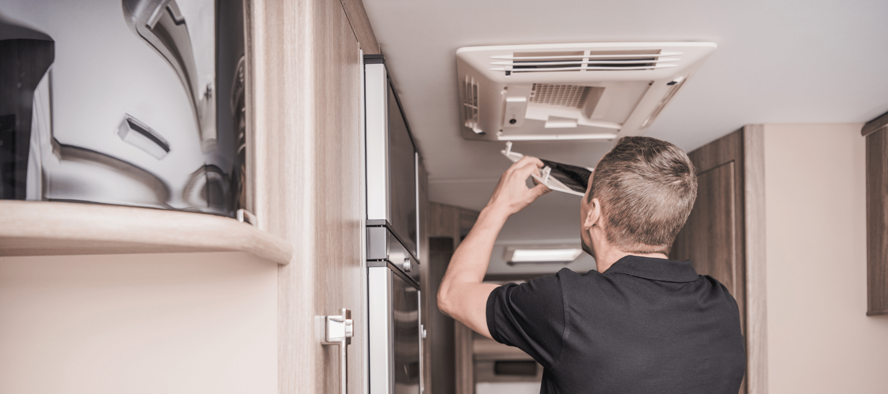 Technician adjusting or inspecting a ceiling air vent in a residential space