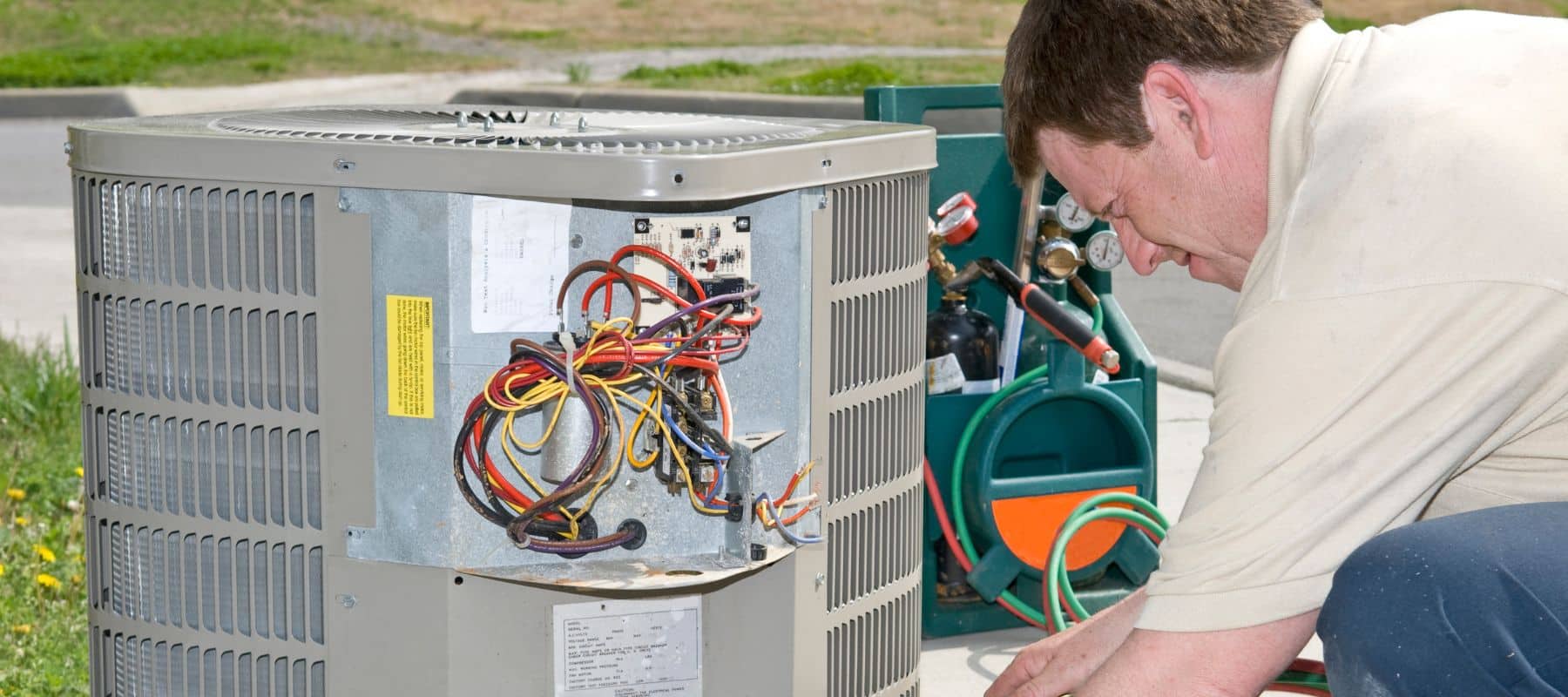 technician performing ac maintenance on an outdoor system