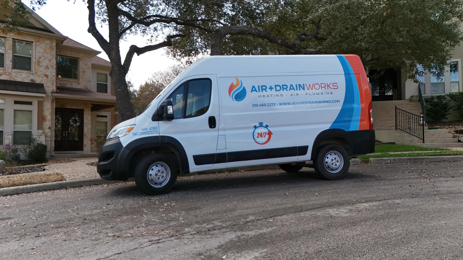 Service van parked in front of a residential building, featuring company branding.