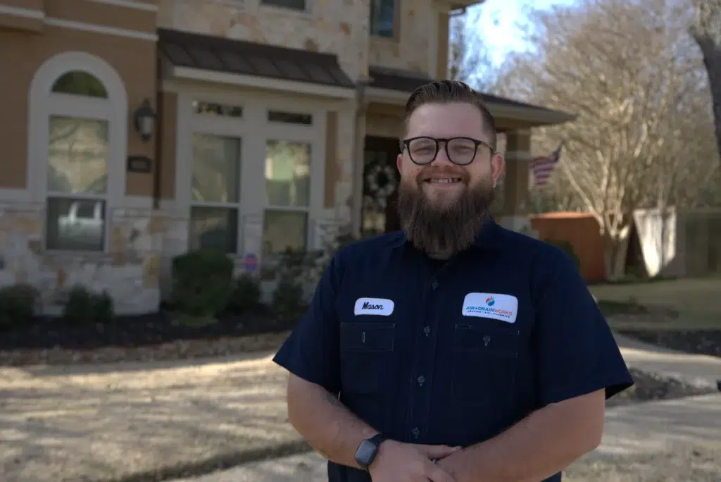 Air & Drain Works HVAC technician outside a San Antonio home