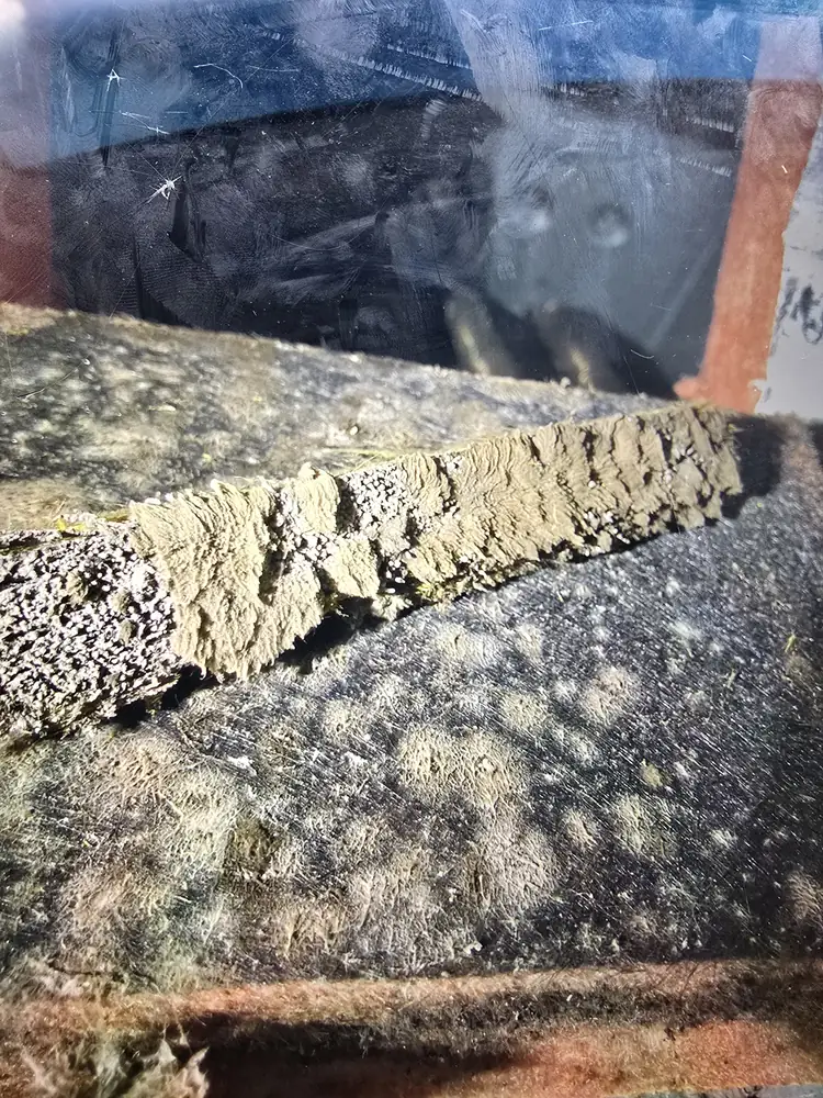 Close-up of mold on fiberglass duct board inside residential ductwork